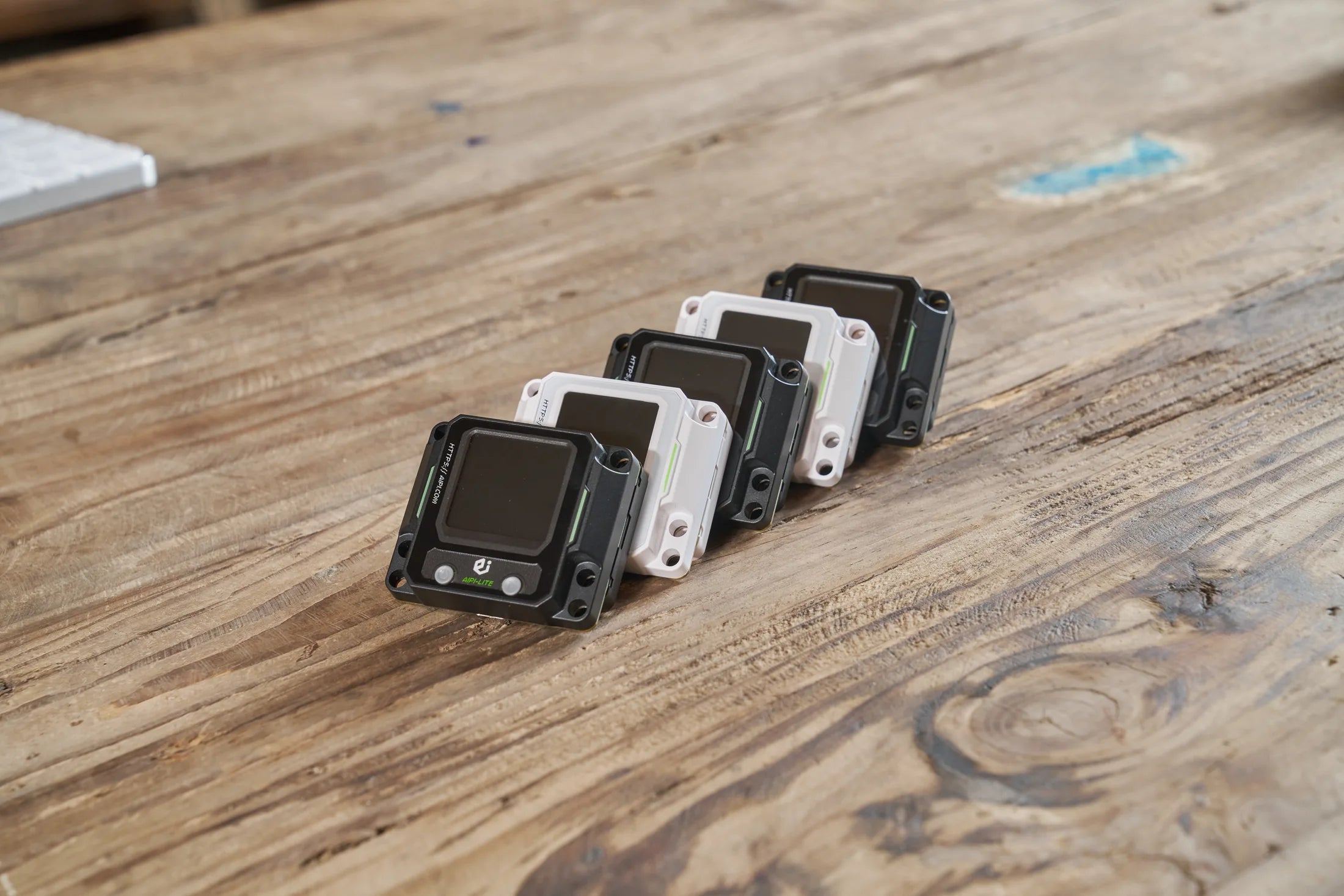Black and white AIPI Lite EVO devices arranged on a worktable