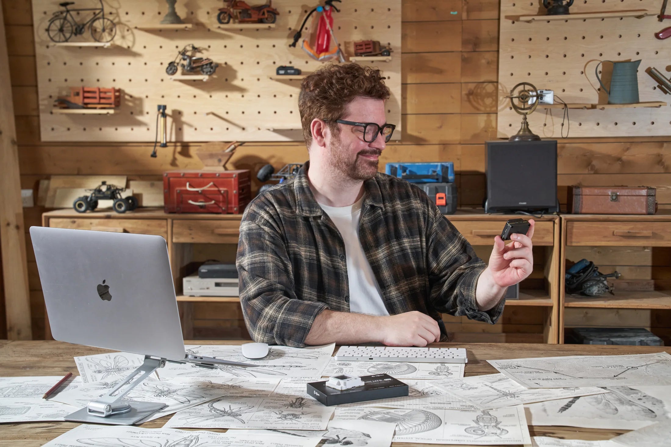 Creator at a workbench holding a black AIPI Lite EVO