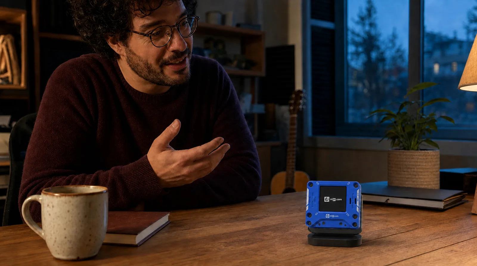 A person talking with a blue AIPI Lite on a home desk